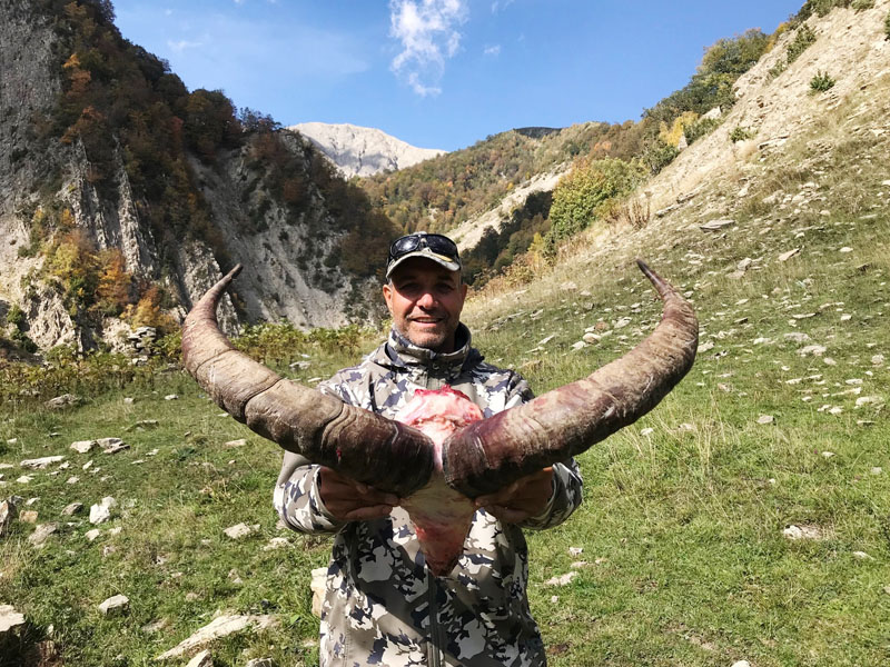 Hunter with a dagestan tur trophy, hunting in Russia