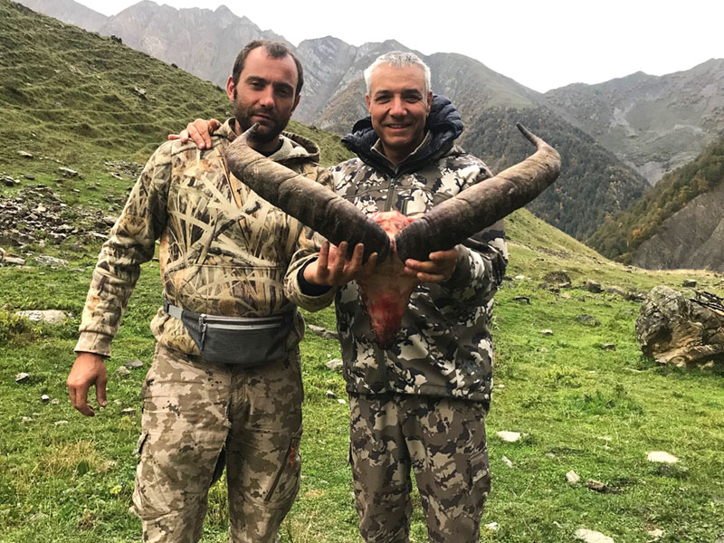 Hunter with a dagestan tur trophy, hunting in Russia