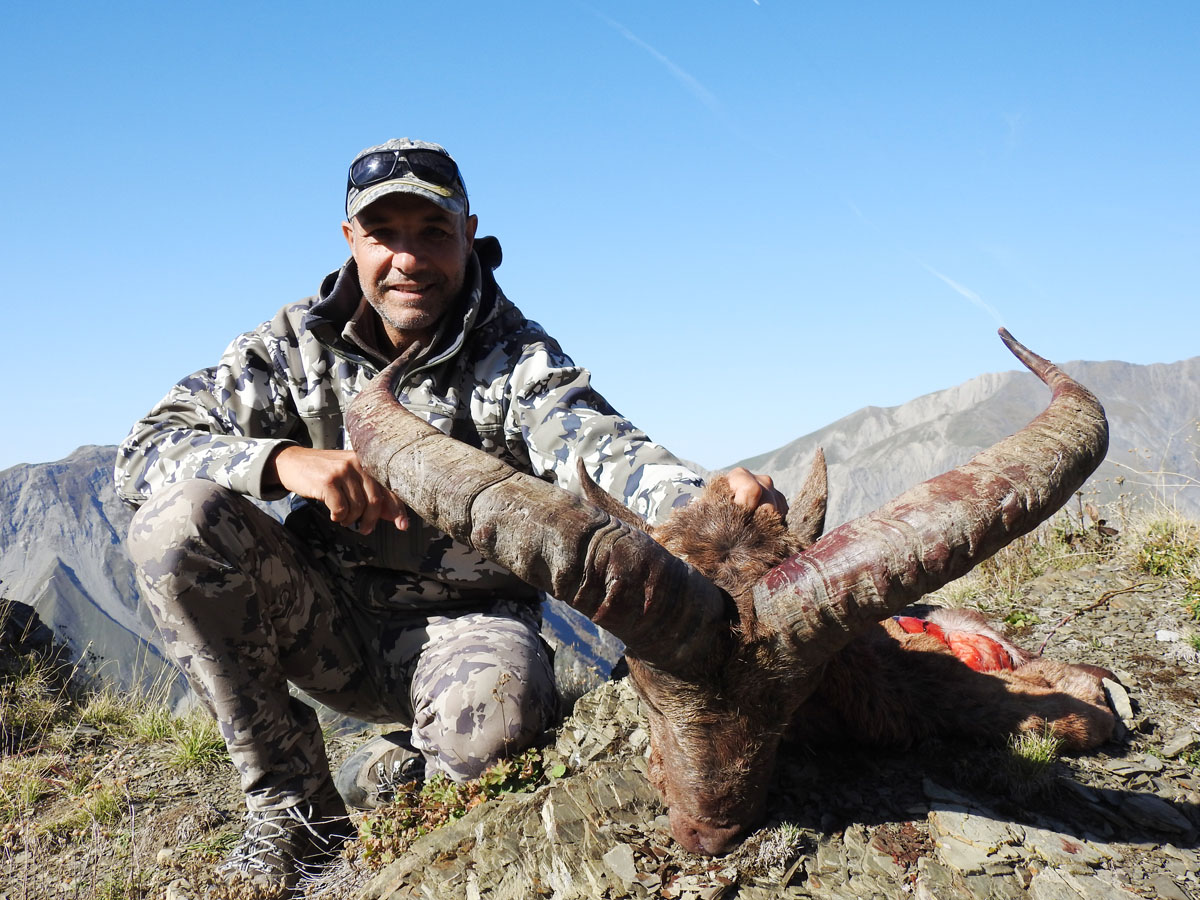 Hunter with a big dagestan tur trophy, hunting in Russia