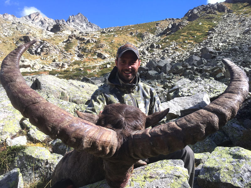 Hunter with a Midcaucasian tur trophy, hunting in Russia