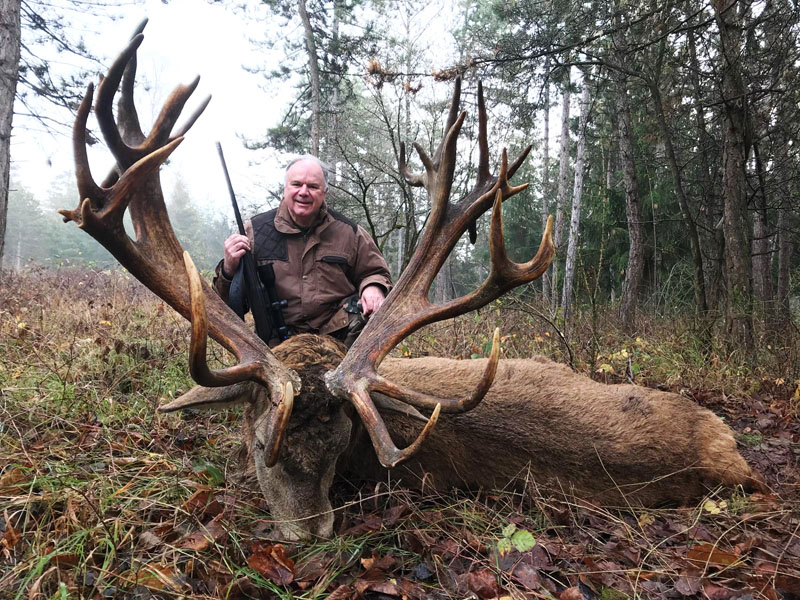 Hunter with a big red stag trophy in France