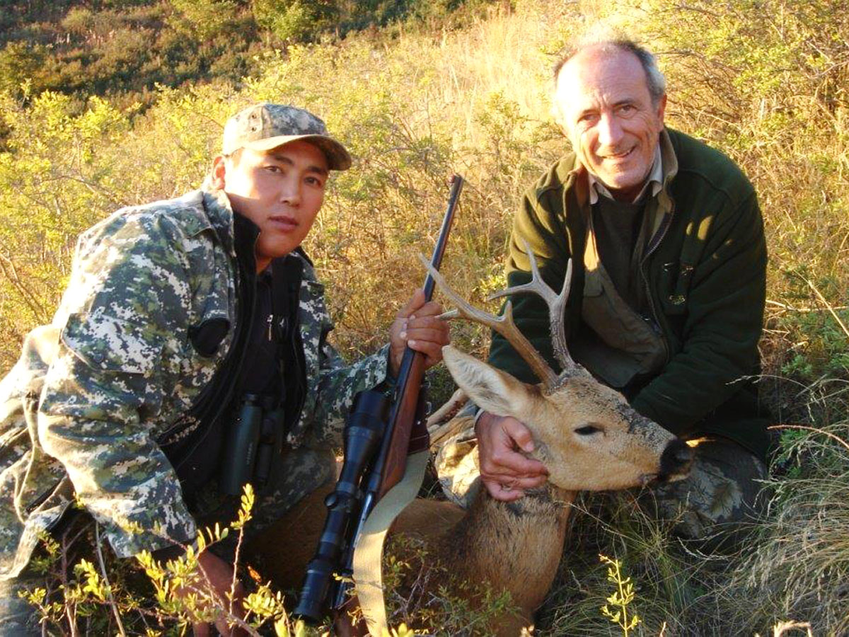 Hunter with a siberian roebuck, hunting in Russia